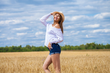 Young brunette woman in white shirt and blue jeans shorts