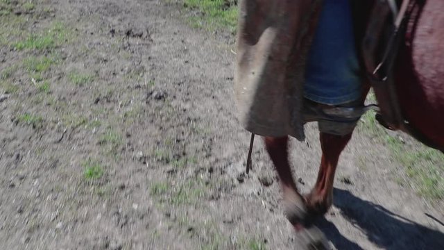 Focusing on the stirrups, the camera shifts down to reveal the horses path