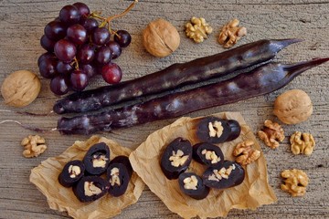Caucasian delicacy churchkhela with grapes and walnuts on a wooden background close-up.
