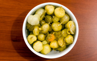 Marinated chili peppers on a wooden background. 