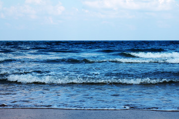 Blue waves of the Mediterranean Sea against the blue sky