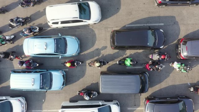 JAKARTA, Indonesia - August 07, 2019: Top down view of vehicle moving slowly during rush hour on the street at the morning. Shot in 4k resolution from a drone flying upwards