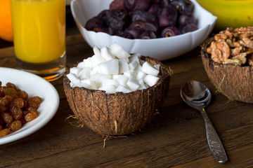 Healthy raw foods breakfast concept. Coconut, walnuts, raisins, date fruits.