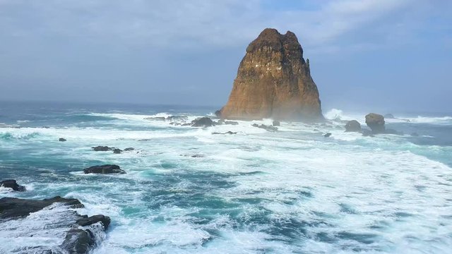 Beautiful landscape of Papuma beach with frothy waves and coral background, Jember, East Java, Indonesia. Shot in 4k resolution
