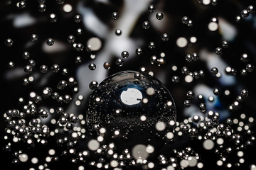 A Large Chrome Sphere Crisply reflecting Hundreds of tiny polished  chrome ball bearings cascading...