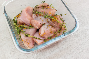 Fototapeta na wymiar Raw turkey slices with thyme and mustard marinade ready to bake or grill