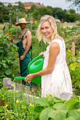 couple in the garden watering the flowers