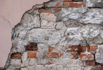 old dilapidated brick wall, crumbling plaster