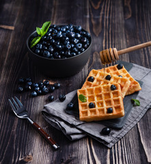 fresh sweet blueberry with aromatic belgian waffels and honey dark wood table