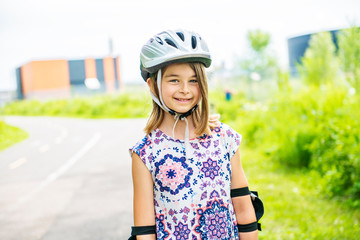 Child on inline skates. Little girl skating on sunny summer day.