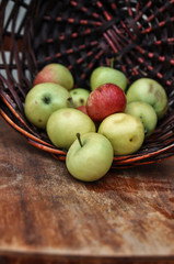 Basket with ripe fresh apples on an old chair. Harvest.