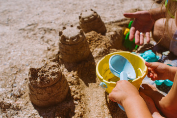 Closeup of kid building castle from sand on the beach