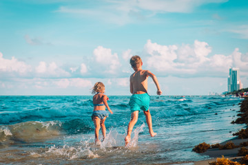 happy boy and girl run play at beach