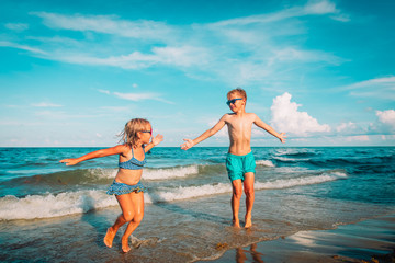 happy cute boy and girl play on beach