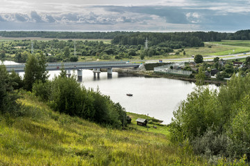 Obraz premium Aerial view of the river village with beautiful houses and many green trees, life in the country concept. Clip. Summer nature, residential houses on river bank.