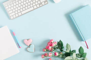 Composition Valentine's Day. Keyboard, notepad, rose flowers, ginger cookie in shape heart on pastel blue background. Valentine day concept, design. Flat lay, top view, copy space