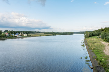 Beautiful landscape view of the rivers bank with house and trees. During sunny summer day in Belarus
