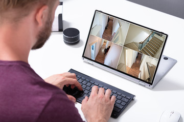 Businessman checking CCTV camera footage on laptop