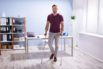 Fototapeta na wymiar Handicapped Man Walking With Crutches