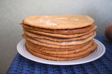 Round baked cake layers stacked on a plate. Homemade cakes. Cooking honey cake at home.