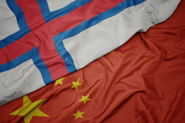 waving colorful flag of china and national flag of faroe islands.