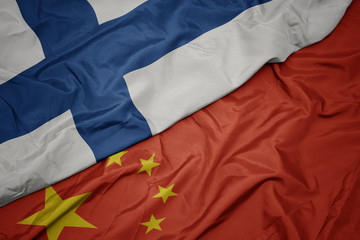 waving colorful flag of china and national flag of finland.