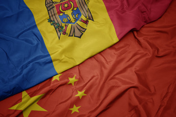 waving colorful flag of china and national flag of moldova.