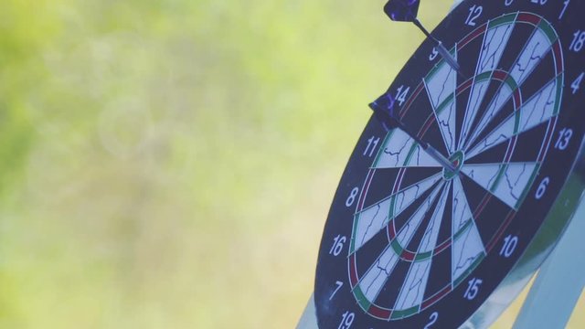 Hands of a child close-up on a background of darts toys.
