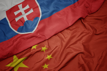 Fototapeta premium waving colorful flag of china and national flag of slovakia.