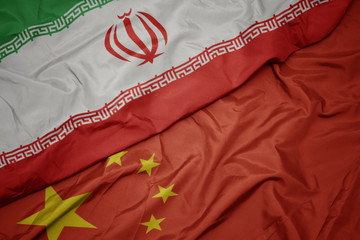 waving colorful flag of china and national flag of iran.