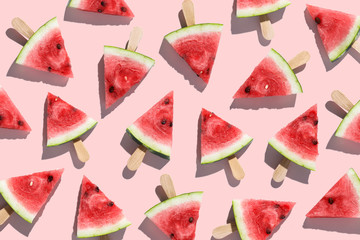 Sliced watermelons arranged on a pink background