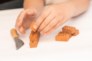 Construction of small brick blocks, toy for child development on white background.