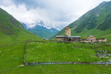 View of the Ushguli village at the foot of Mt. Shkhara. Lamaria Monastery, Rock tower towers and old houses in Ushguli.