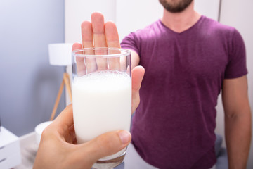 Man Rejecting Glass Of Milk