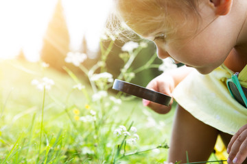 Girl Looking At Flower Through Magnifying Glass