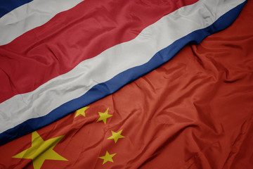 waving colorful flag of china and national flag of costa rica.