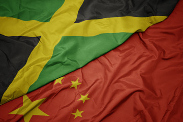 waving colorful flag of china and national flag of jamaica.