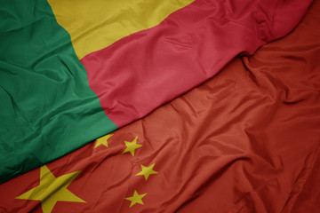 waving colorful flag of china and national flag of benin.