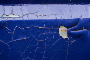 Close-up of old blue car paint broken, crack color of automobile.Car paint cracks, Cracked painted metal surface. Closeup of cracked and peeling paint on an old car.