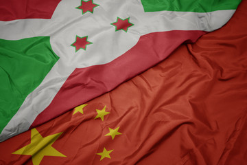 waving colorful flag of china and national flag of burundi.