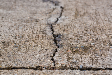 Worn and cracked asphalt with big cracks. Old road concrete texture with cracks. Cement cracked background. Cracks on concrete.