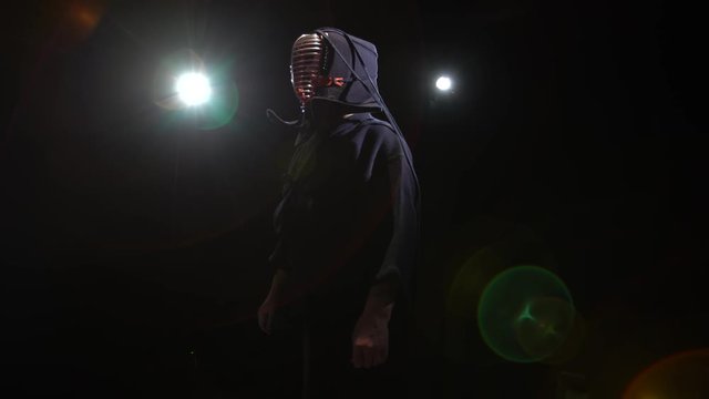 Athletic Kendo instructor is posing for the camera in twilight.