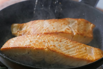 Frying red fish in pan. Pieces of red fish.