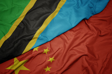 waving colorful flag of china and national flag of tanzania.