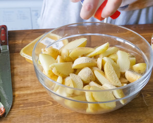 Raw potatoes cutting and peeling on table in a plate