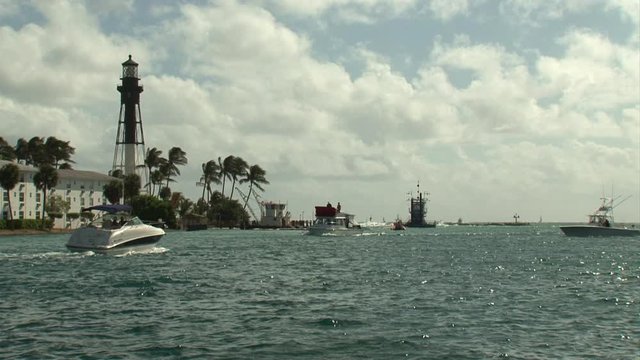 wide shot of Lighthouse Point Florida with fishing boats passing by on a sunny day