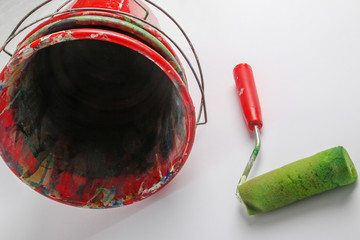 Paint roller and bucket in front of white background