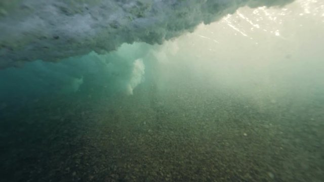 Under water view of barelling ocean wave with vast of foam and bubbles.