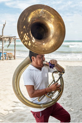 Musician man playing the tuba. Blowing hard as to make sound in that instrument - obrazy, fototapety, plakaty