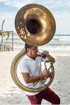 Musician man playing the tuba. Blowing hard as to make sound in that instrument